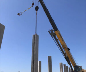 Crew setting precast columns for wing wall on a very windy day at Aquarena Springs Dr and IH35N